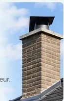 Conduit de cheminée en briques surmonté d'un chapeau métallique, vu depuis le toit